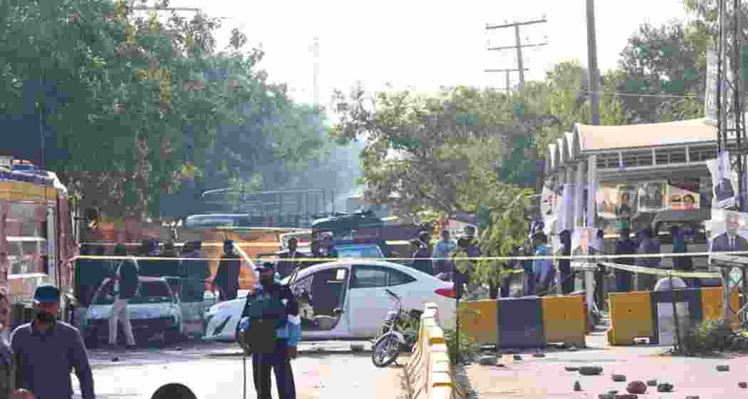 Security personnel gather near the site of twin roadside explosions in Bannu district, Pakistan, where seven people were killed and three others were injured.