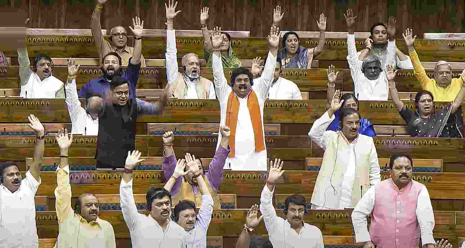 MPs react after Union Home Minister Amit Shah tabled three bills in the Lok Sabha during the Monsoon session of Parliament, in New Delhi, Wednesday.