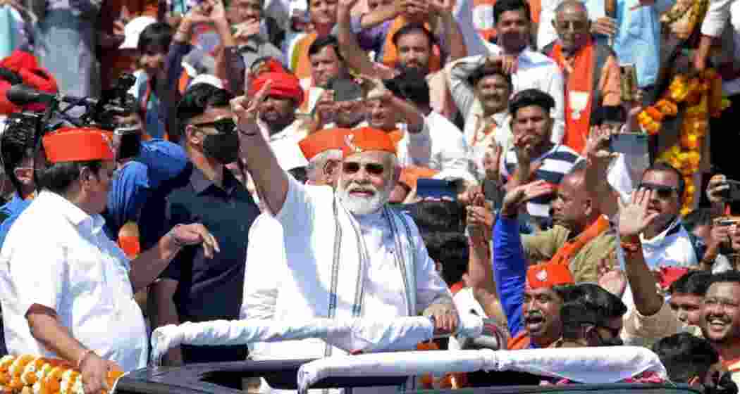 Prime Minister Narendra Modi waves to supporters during a rally in Gujarat.