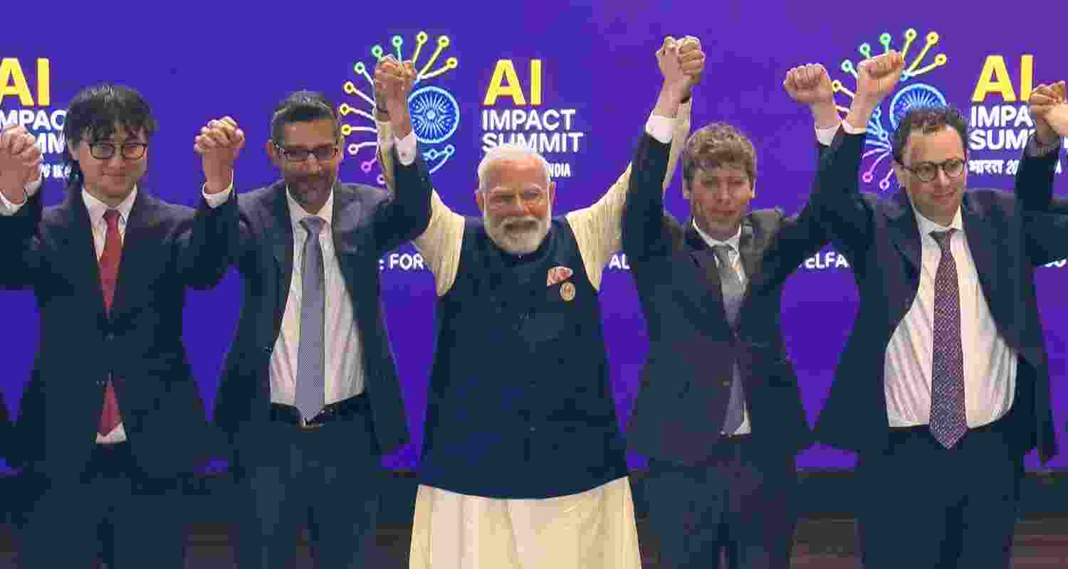 Prime Minister Narendra Modi (C) joins hands with Google CEO Sundar Pichai, OpenAI CEO Sam Altman and others during the India AI Impact Summit 2026, in New Delhi.