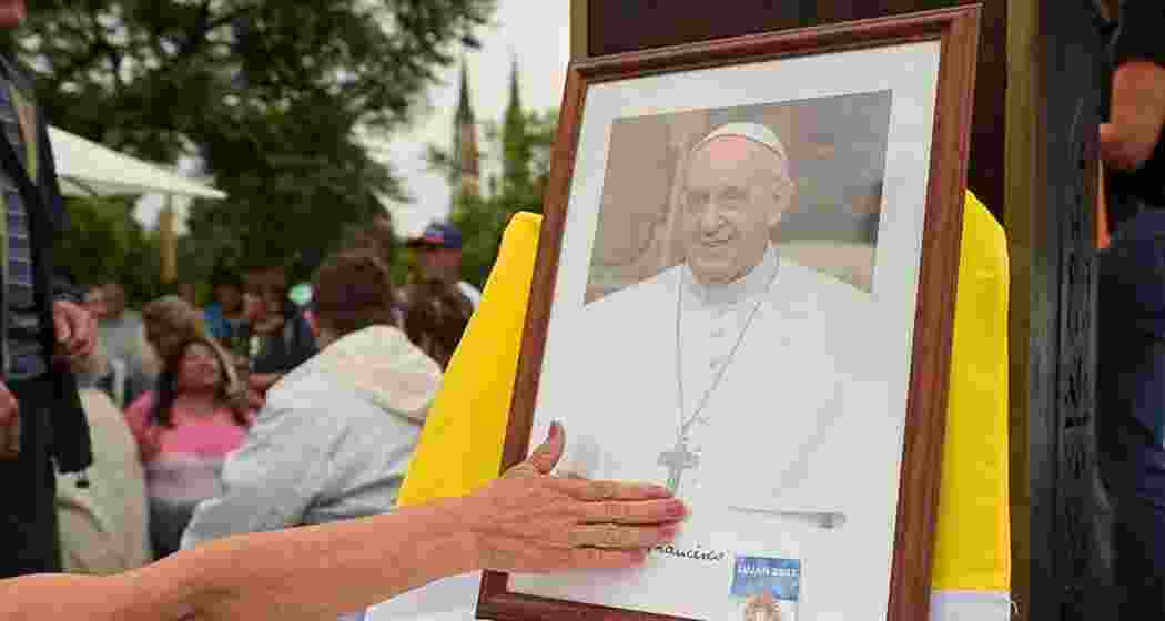 A person touches a portrait of Pope Francis during a Mass to pray for Pope Francis' health at the Plaza Constitucion in Buenos Aires, Argentina, Feb. 24, 2025.