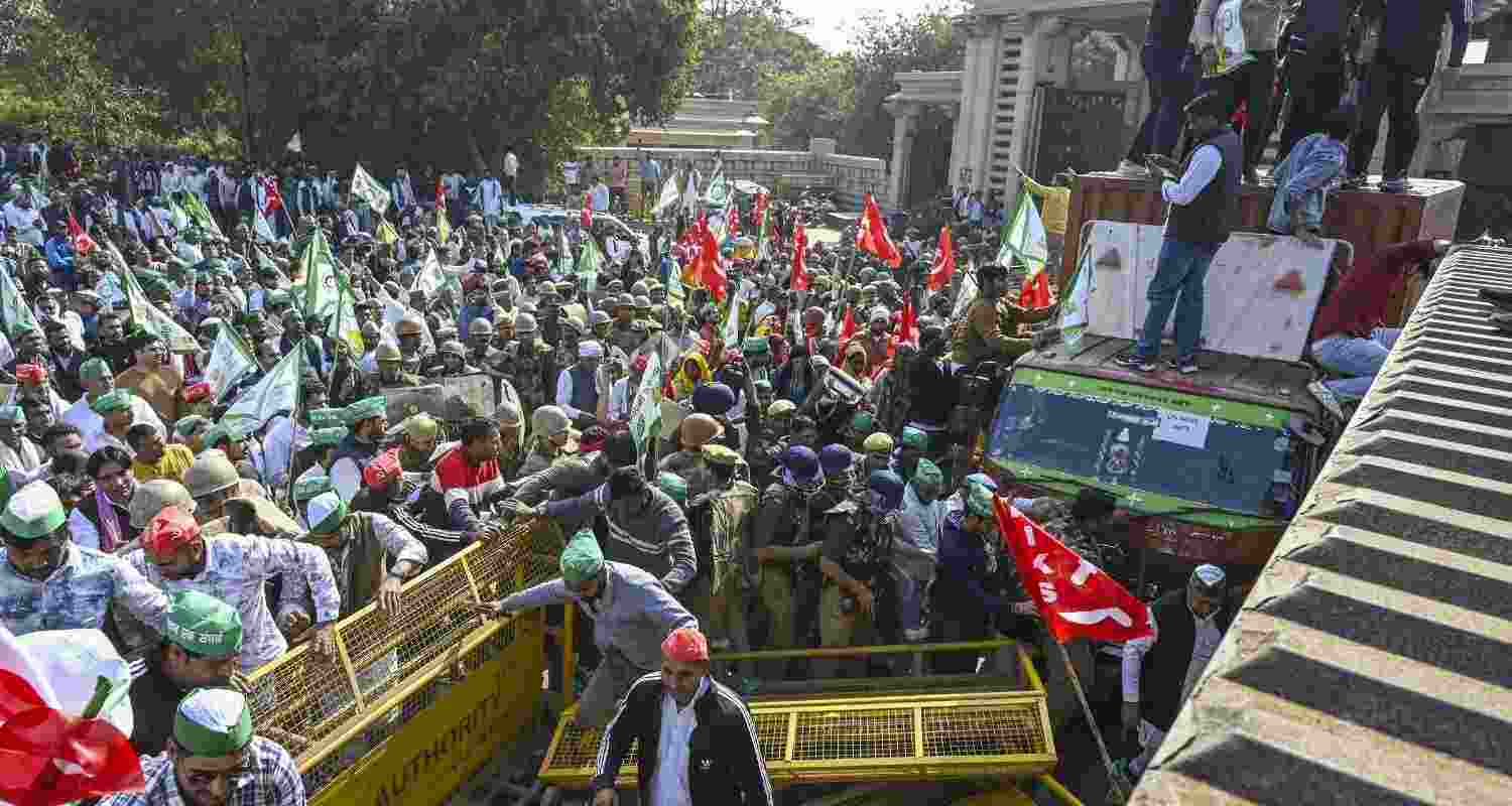 Protesting farmers break through barricades in Noida. 