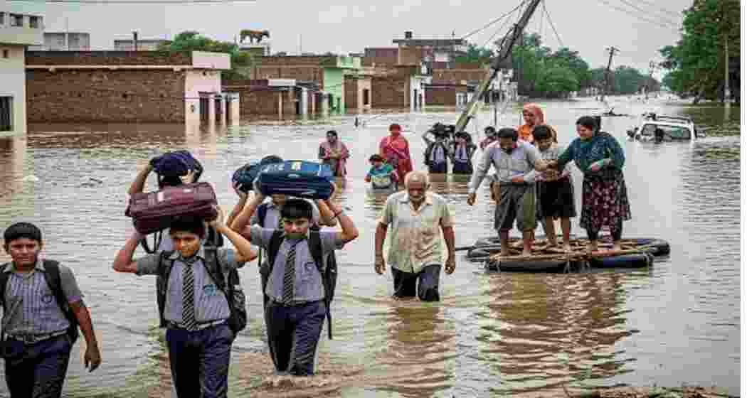 A file photo of students returning home from school through a flooded road in Punjab.