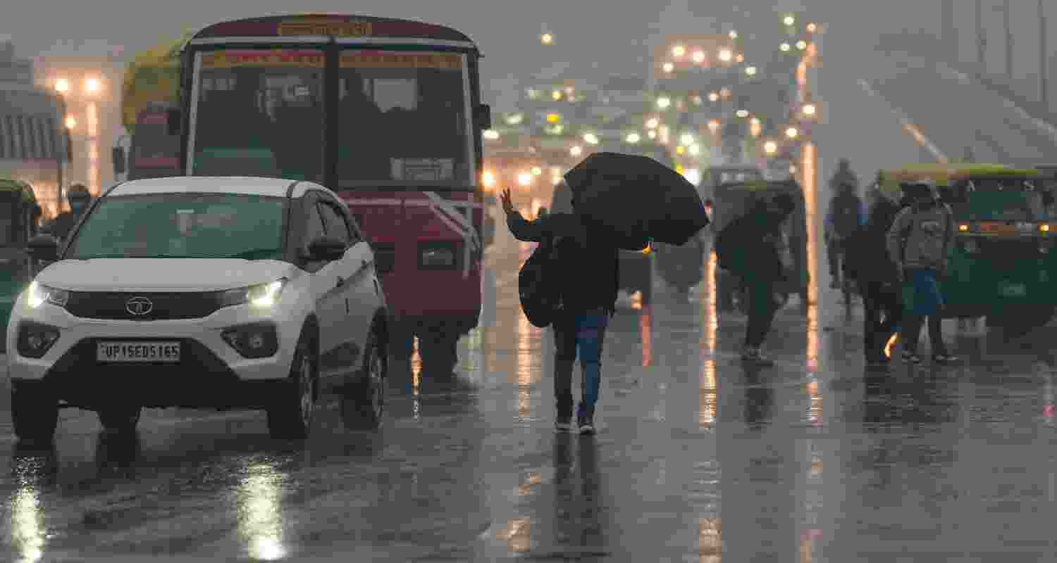  Vehicles move on a road amid rain, in Noida, Friday. 