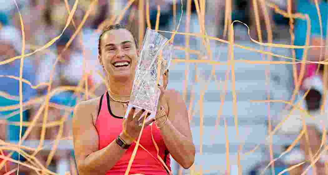 Aryna Sabalenka celebrates with the Miami Open trophy after defeating Coco Gauff in the final, securing her second straight title and completing the prestigious ‘Sunshine Double’.