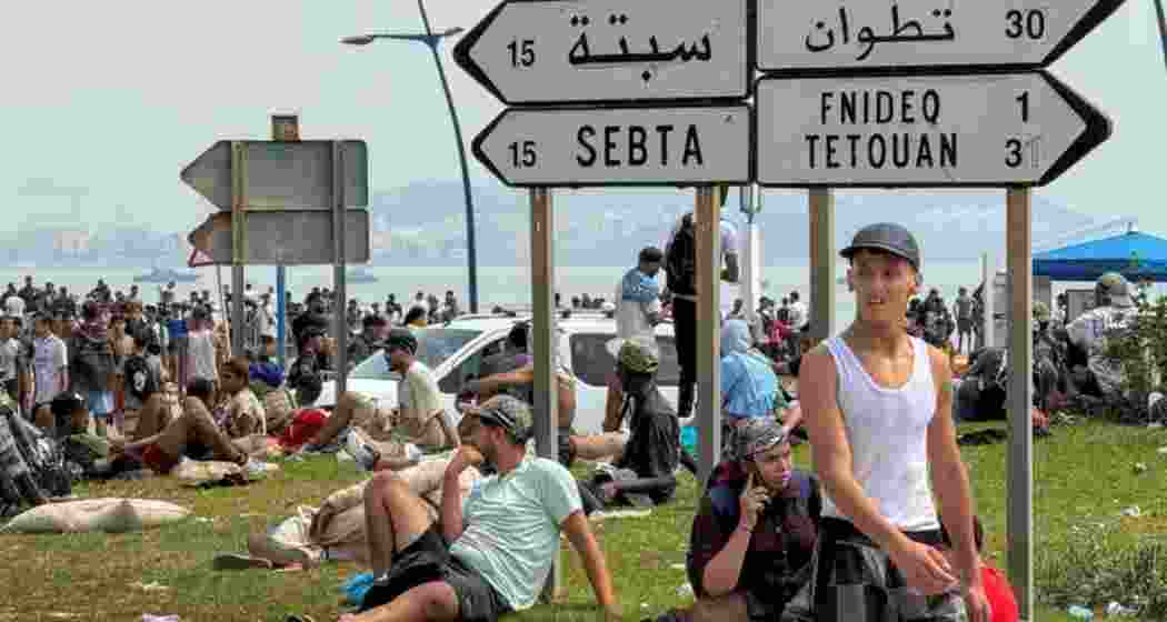 Migrants rest after crossing back from the Spanish enclave of Ceuta, to the Moroccan side of the border in Fnideq, Morocco.