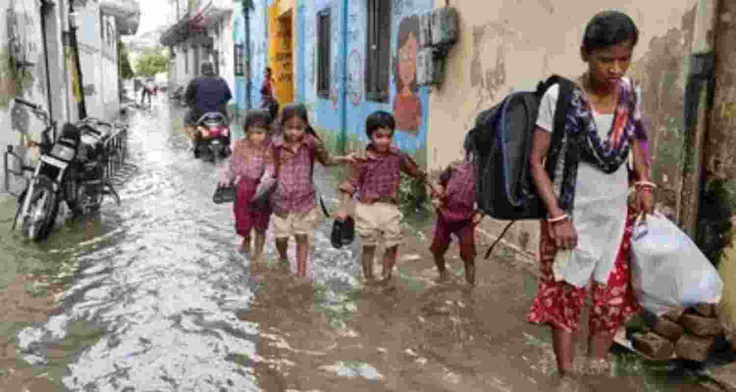 A file photo of children wading through a waterlogged road to get to school in Patiala.
