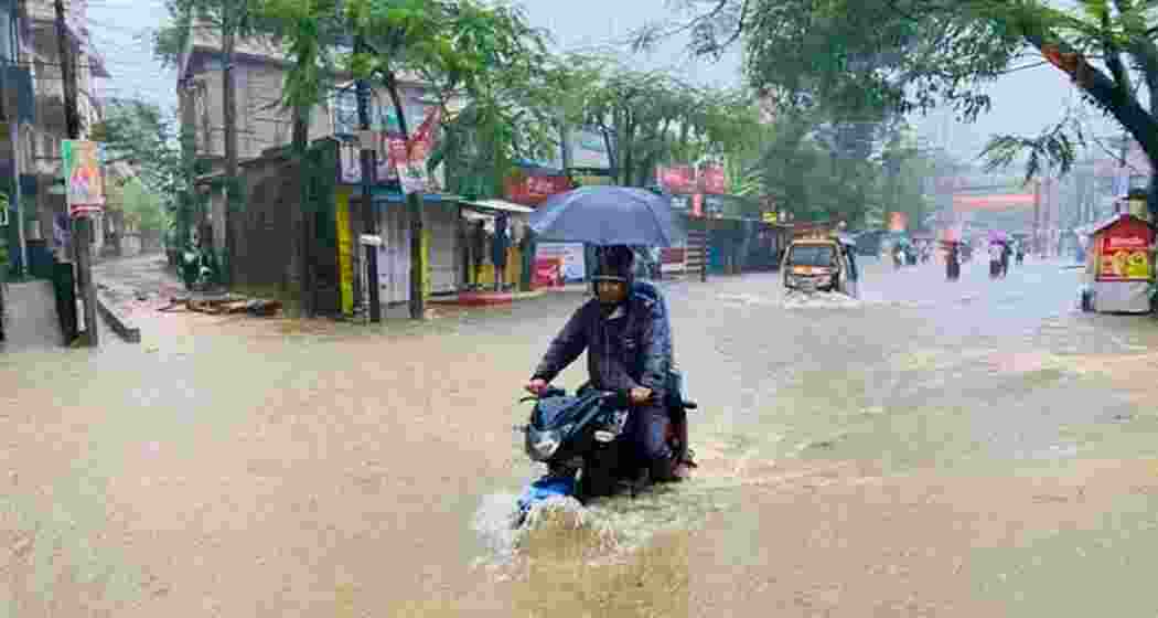 People ride a motorbike through an inundated road in Silchar on Sunday, after the city recorded its highest single-day rainfall in 132 years.
