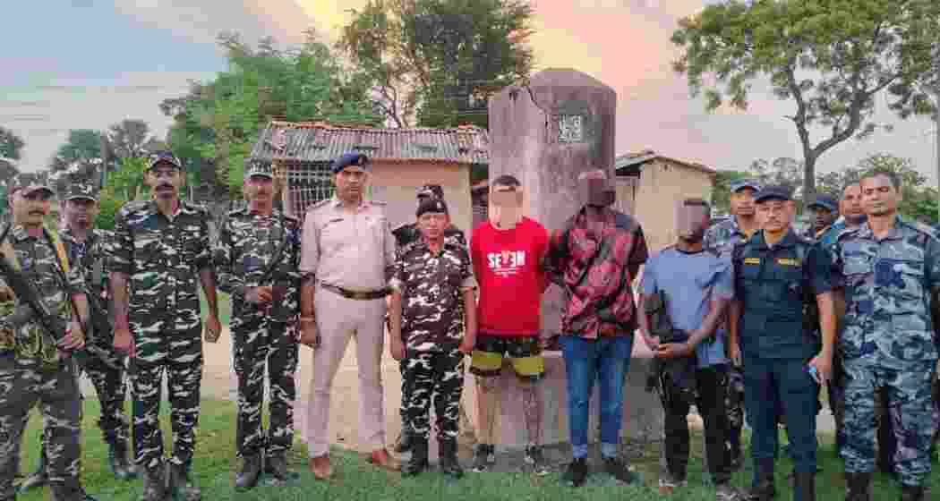 SSB personnel stand with the detained Brazilian and Nigerian nationals.