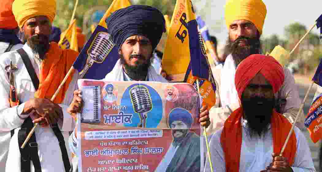 Supporters of jailed radical leader Amritpal Singh hold his posters during a gathering in Punjab. The upcoming Tarn Taran bypoll is seen as a test of his growing influence.