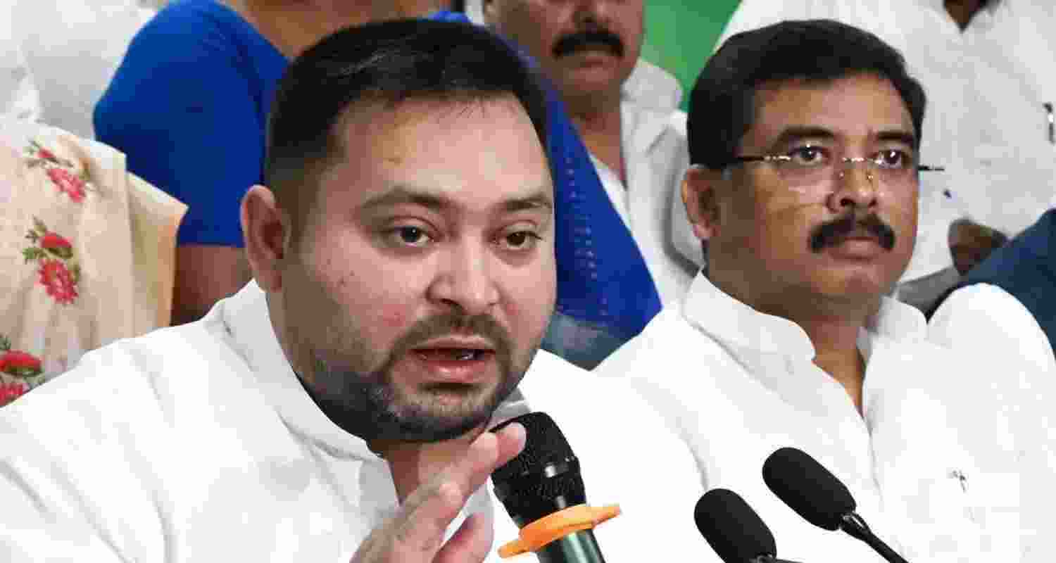 Tejashwi Yadav addressing INDIA bloc press conference in Patna, with Ashok Gehlot accompanying him on stage. 