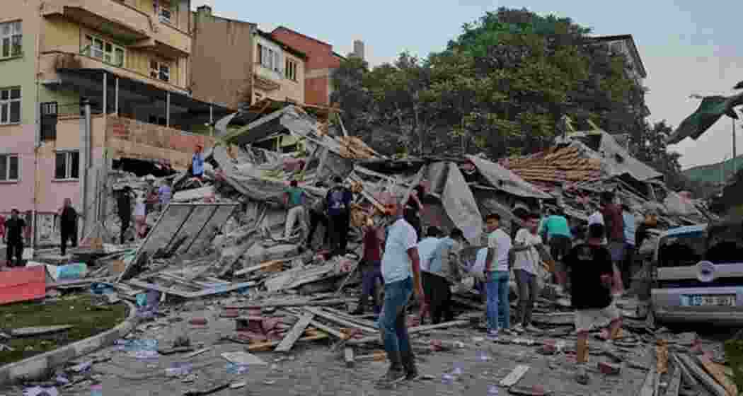 People remove the wreckage of a collapsed building following an earthquake in Sindirgi, northwest Turkey.