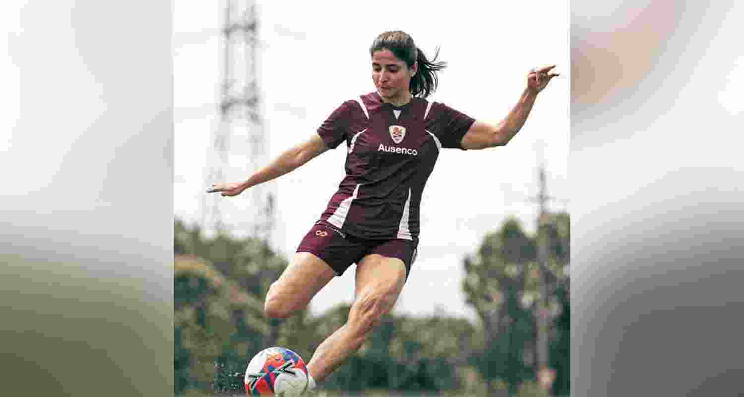Iranian football player Atefeh Ramezanisadeh kicks a ball at a Brisbane Roar club training session in Australia.
