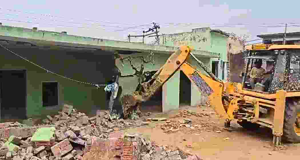 An earth mover demolishes a structure built on government land during an anti-encroachment drive in Sambhal district of Uttar Pradesh on Friday.