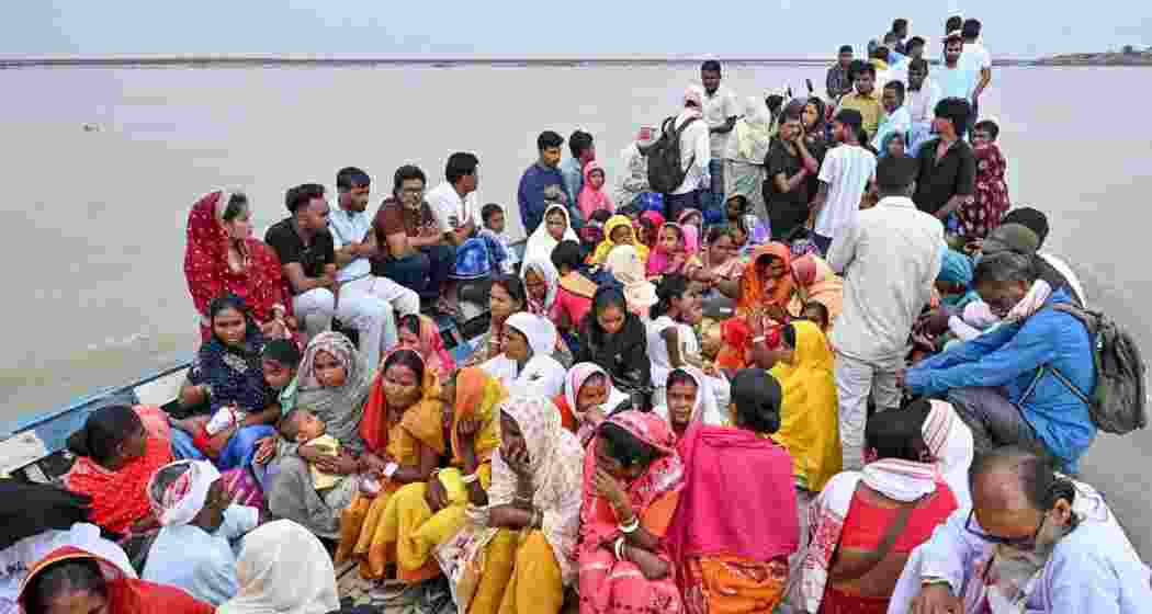 People cross the Brahmaputra river on a boat to casts their votes in the Assam Assembly elections, in Darrang, on Thursday.