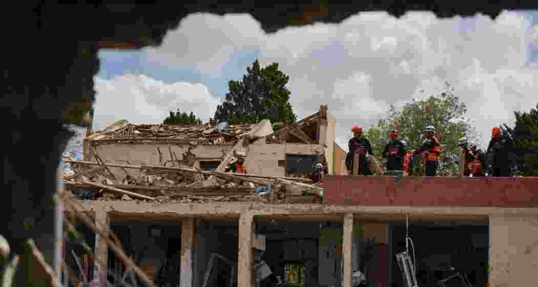 Israeli security forces survey the site that was struck by an Iranian missile in Dimona, southern Israel on Sunday.