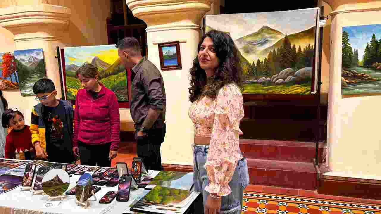 Visitors exploring a diverse collection of artworks at “Harmony in Hues”, a five-day solo art exhibition by Garima Lohumi, at Gaiety theatre in Shimla on Monday.