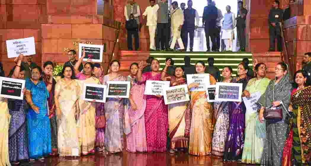  NDA MPs raise slogans during a protest amid rain, after the Constitution Amendment Bill to implement reservation for women in legislatures in 2029 and increase the number of seats of the Lok Sabha was defeated, during the Special session of Parliament, in New Delhi, on Friday.