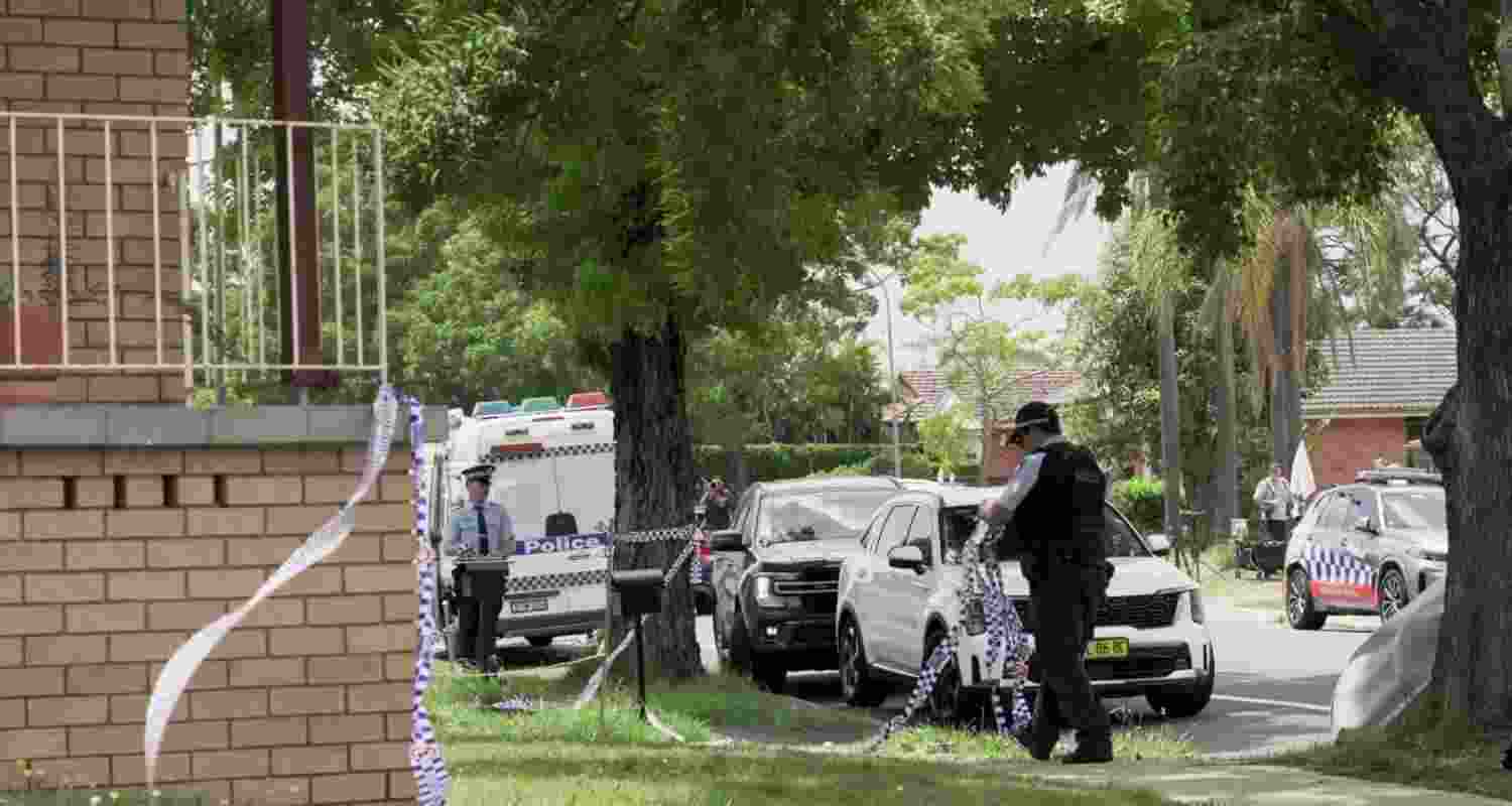 A police officer removes police tape from outside the house of the suspects of a shooting incident on a Jewish holiday celebration at Bondi Beach, in Bonnyrigg, Sydney. A police officer removes police tape from outside the house of the suspects of a shooting incident on a Jewish holiday celebration at Bondi Beach, in Bonnyrigg, Sydney.