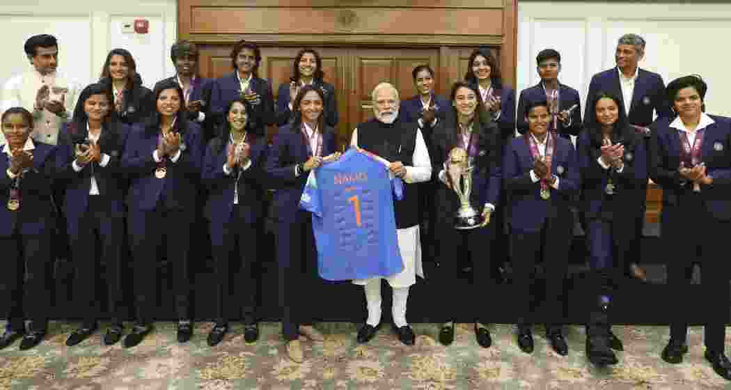 Prime Minister Narendra Modi holds a jersey with captain Harmanpreet Kaur as he poses for a photograph with the Indian women's cricket team, in New Delhi on Wednesday. Prime Minister Narendra Modi holds a jersey with captain Harmanpreet Kaur as he poses for a photograph with the Indian women's cricket team, in New Delhi on Wednesday.