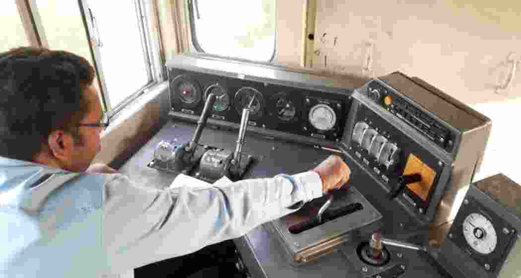 A loco pilot focuses intently while managing the train's dashboard. A loco pilot focuses intently while managing the train's dashboard.