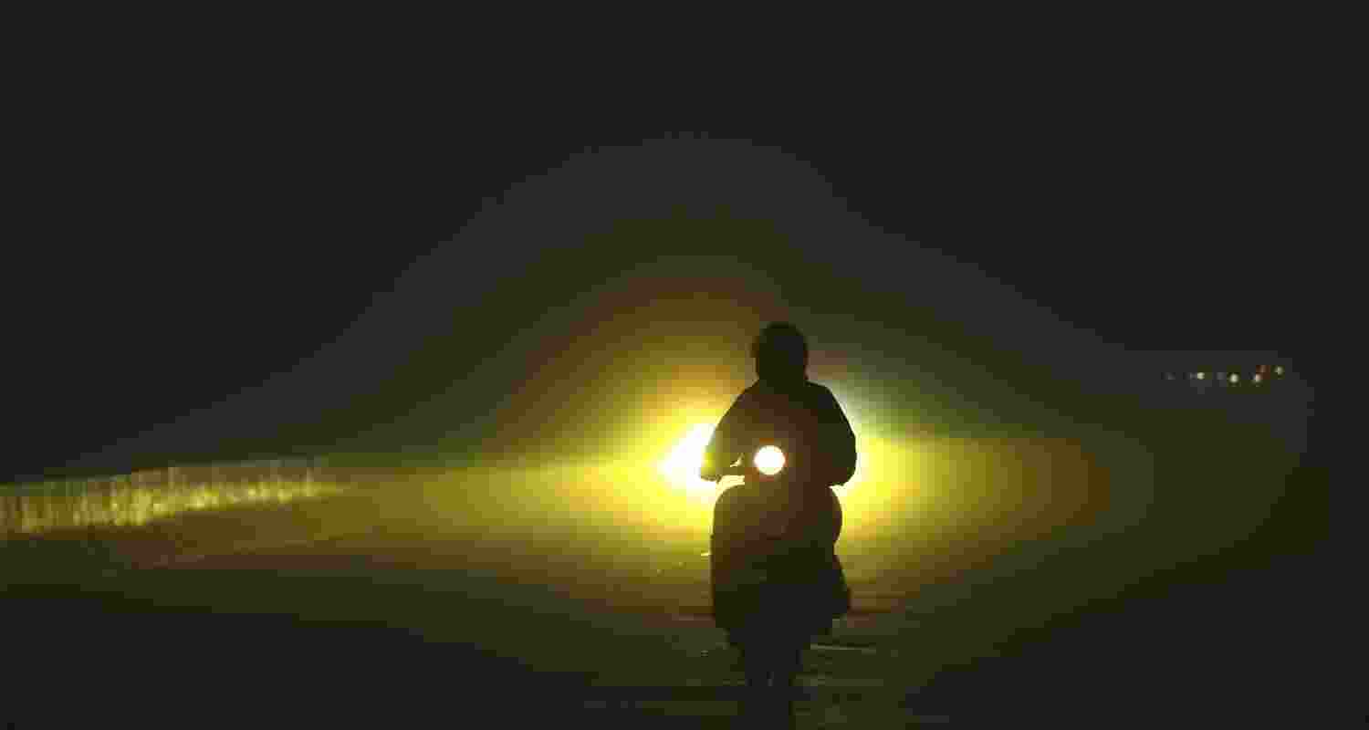 A scooter rider navigates a road amid low visibility on a foggy winter morning, in Jammu. A scooter rider navigates a road amid low visibility on a foggy winter morning, in Jammu.