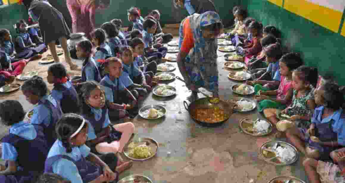 Students being served mid-day meal in a school. Students being served mid-day meal in a school.