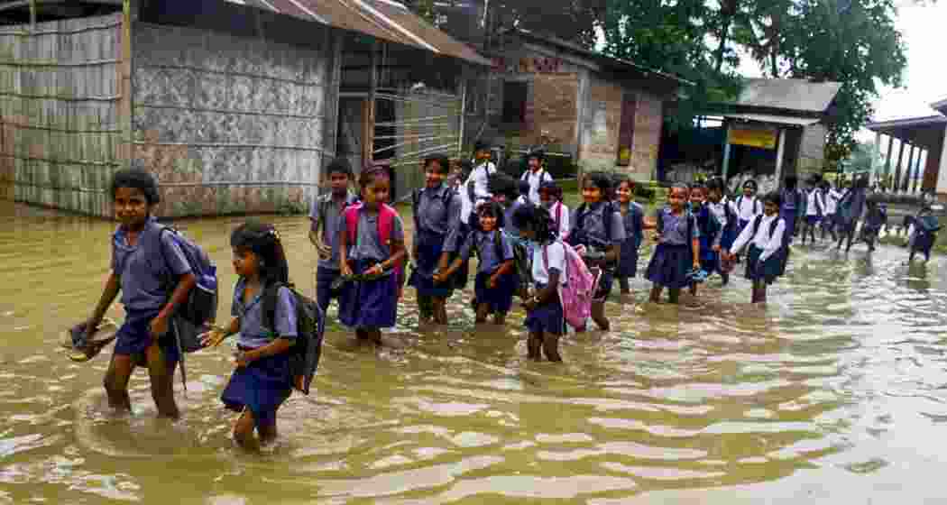 School students wade through floodwaters at Mayang village in Morigaon district of Assam, Tuesday, June 3, 2025. School students wade through floodwaters at Mayang village in Morigaon district of Assam, Tuesday, June 3, 2025.