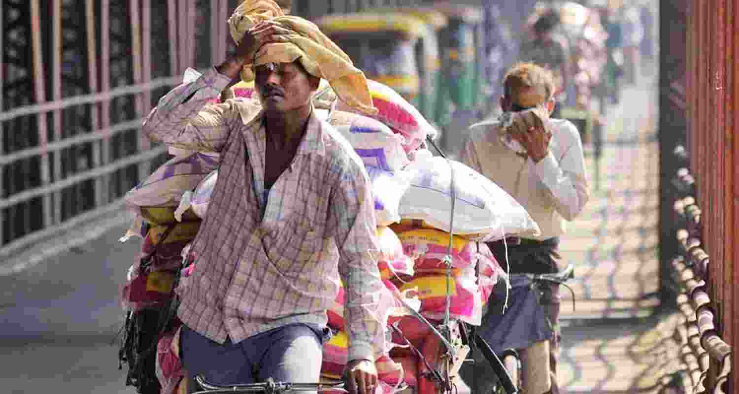 A man mops sweat from his brow while transporting goods on his cycle rickshaw across New Delhi's Old Yamuna bridge in sweltering weather. A man mops sweat from his brow while transporting goods on his cycle rickshaw across New Delhi's Old Yamuna bridge in sweltering weather.