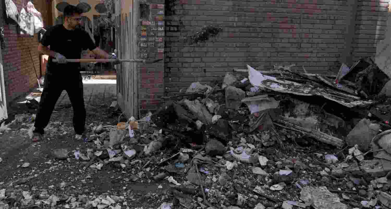 A man clears debris from a building damaged after a nearby residential building was hit in a US-Israeli strike in Tehran, Friday, March 27, 2026. A man clears debris from a building damaged after a nearby residential building was hit in a US-Israeli strike in Tehran, Friday, March 27, 2026.