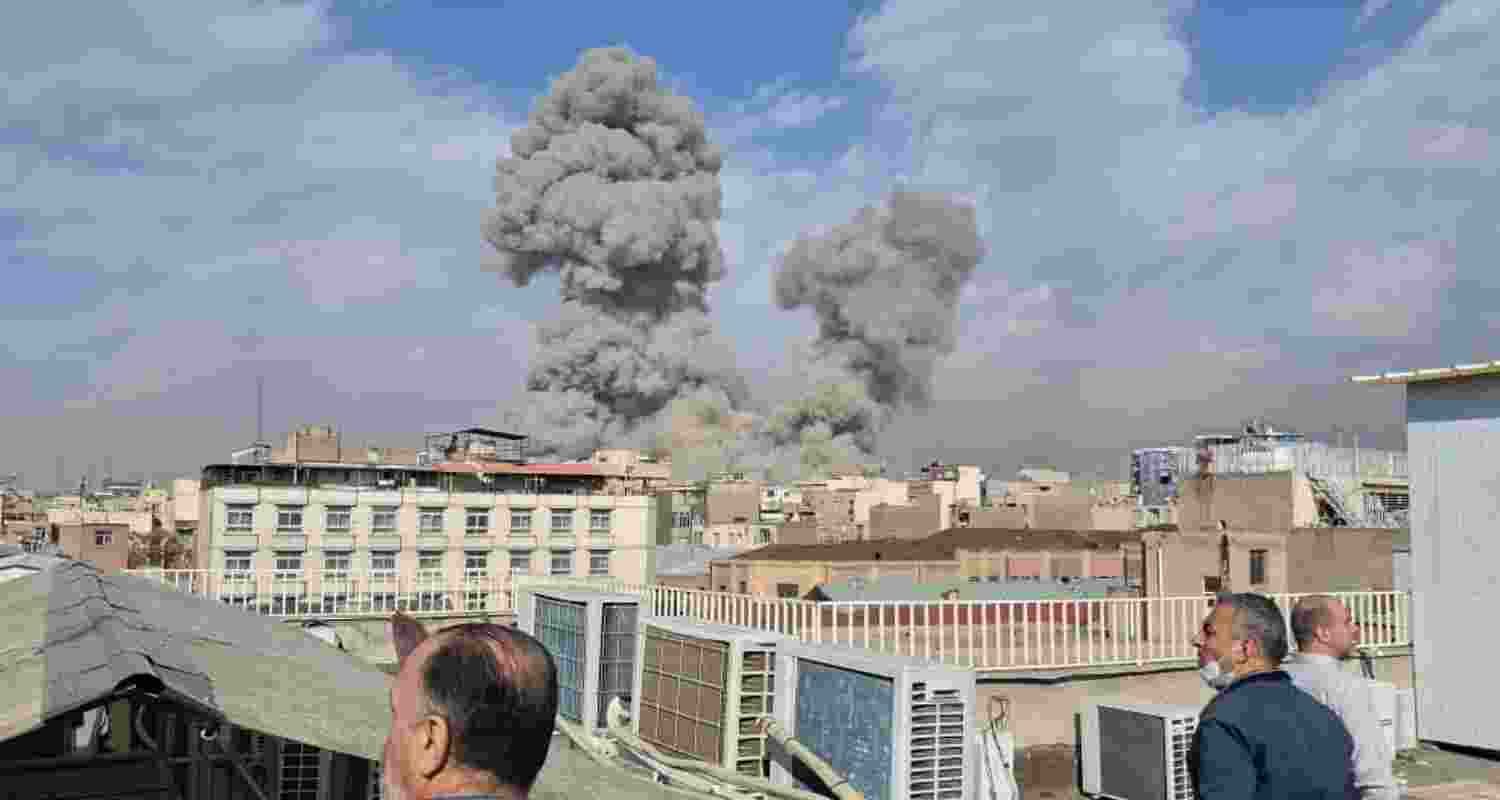 People watch as smoke rises on the skyline after an explosion in Tehran, Iran, Saturday. People watch as smoke rises on the skyline after an explosion in Tehran, Iran, Saturday.