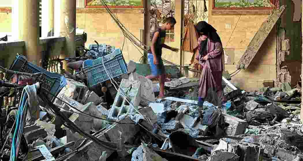 Palestinians inspect the ruins of a school struck by Israeli air raids in Gaza's Sheikh Ridwan, where at least nine people were killed amid rising civilian casualties.
Palestinians inspect the ruins of a school struck by Israeli air raids in Gaza's Sheikh Ridwan, where at least nine people were killed amid rising civilian casualties.