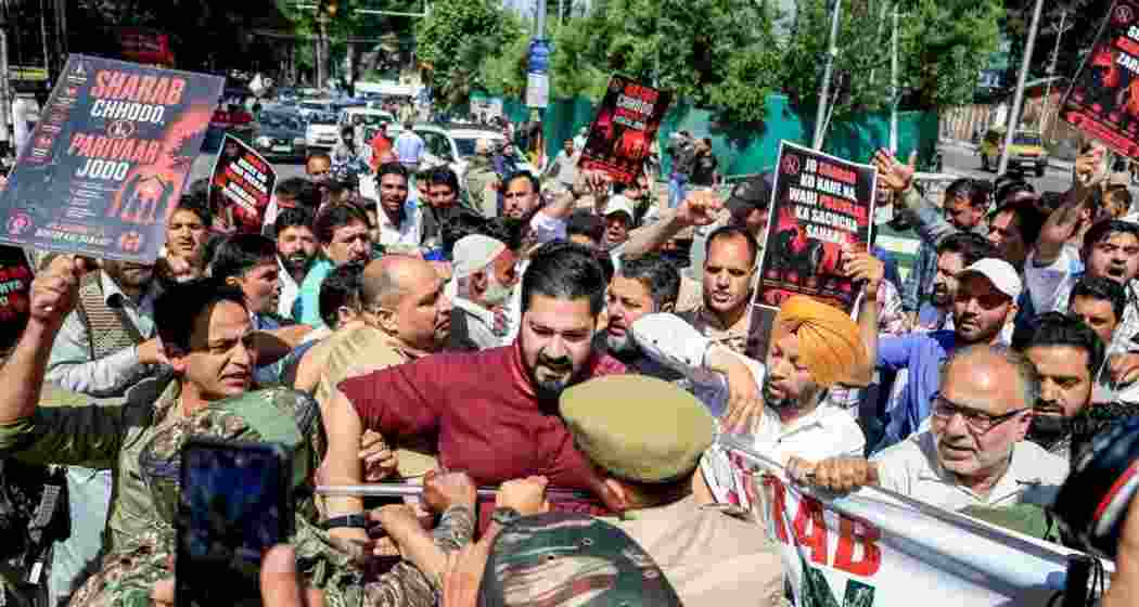 Police and security personnel try to stop BJP leaders and workers as they stage a protest over the demand to ban liquor, in Srinagar. Police and security personnel try to stop BJP leaders and workers as they stage a protest over the demand to ban liquor, in Srinagar.