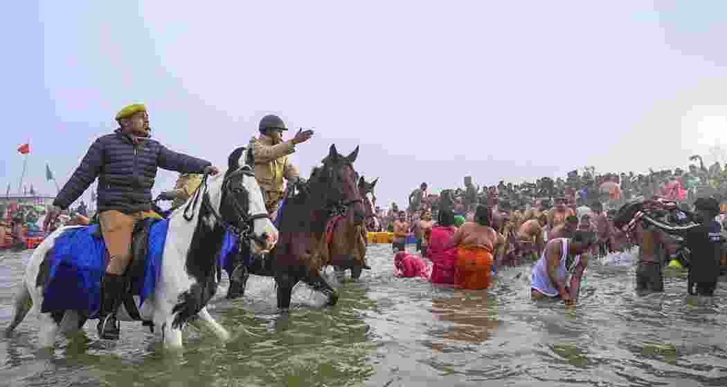 Security personnel try to manage a rush of devotees who arrive to take a holy dip at the Sangam on the 'Makar Sankranti' festival, during the Mahakumbh Mela, in Prayagraj on Tuesday, Jan. 14, 2025. Security personnel try to manage a rush of devotees who arrive to take a holy dip at the Sangam on the 'Makar Sankranti' festival, during the Mahakumbh Mela, in Prayagraj on Tuesday, Jan. 14, 2025.