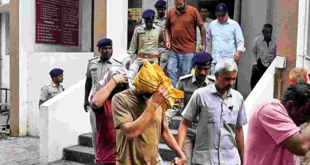 Security personnel escort accused as they come out of a Delhi court after a hearing in the alleged NEET-UG 2026 paper leak case in New Delhi on Monday. Security personnel escort accused as they come out of a Delhi court after a hearing in the alleged NEET-UG 2026 paper leak case in New Delhi on Monday.