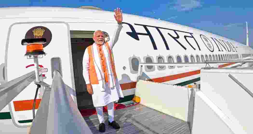 Narendra Modi waves before departing on an international tour. Narendra Modi waves before departing on an international tour.