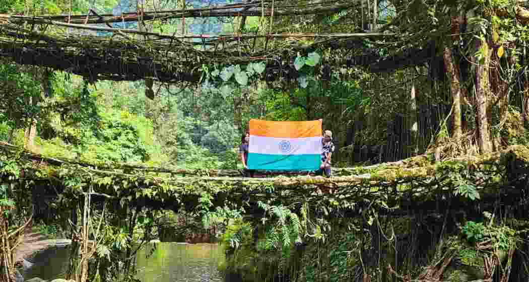 A couple displays the Indian tricolour on a Living Root Bridge in Meghalaya. A couple displays the Indian tricolour on a Living Root Bridge in Meghalaya.