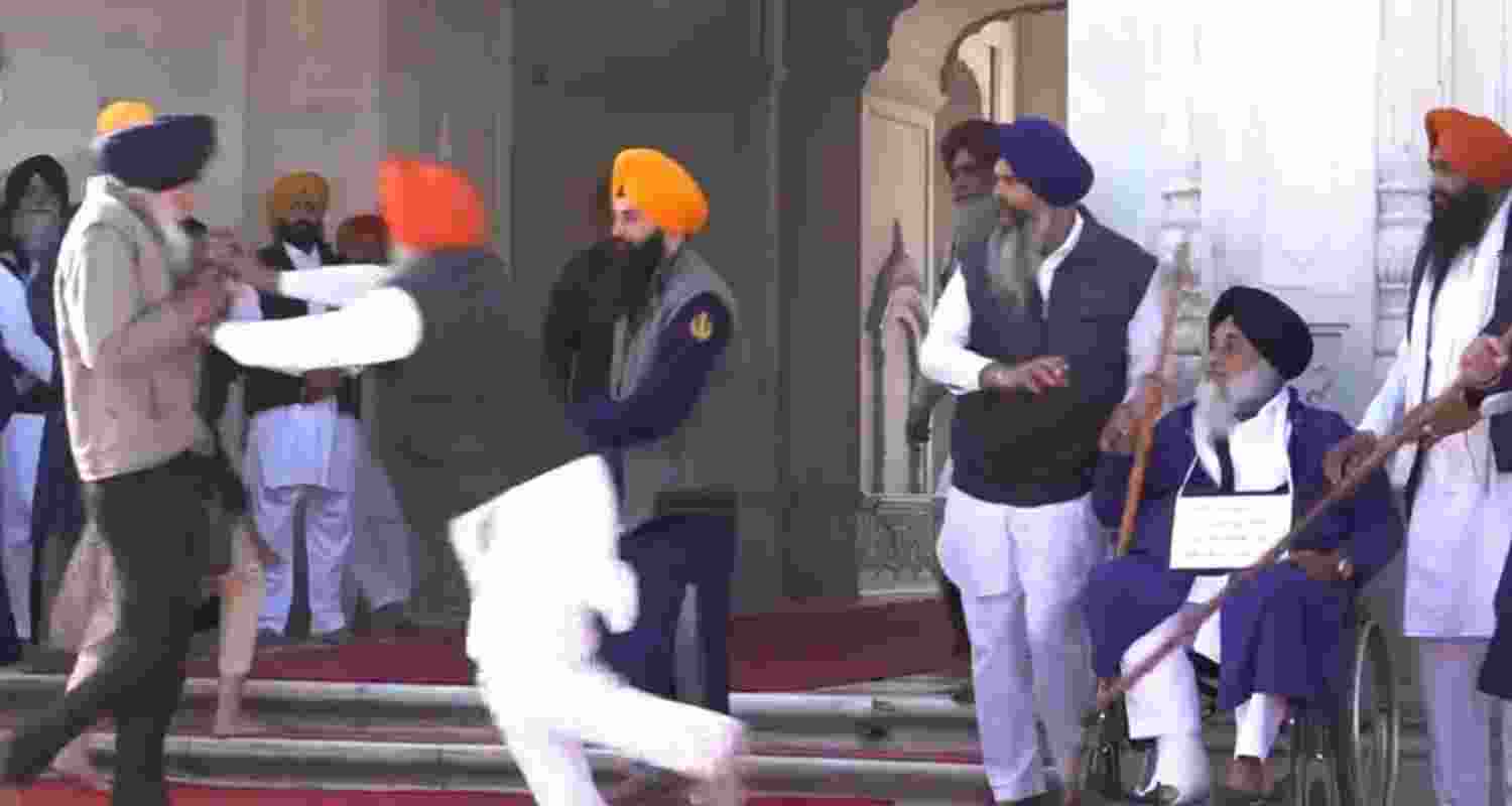 People catch a man who allegedly opened fire at Shiromani Akali Dal leader Sukhbir Singh Badal while the latter was performing the duty of 'sewadar' outside the Golden Temple, in Amritsar, Wednesday. People catch a man who allegedly opened fire at Shiromani Akali Dal leader Sukhbir Singh Badal while the latter was performing the duty of 'sewadar' outside the Golden Temple, in Amritsar, Wednesday.