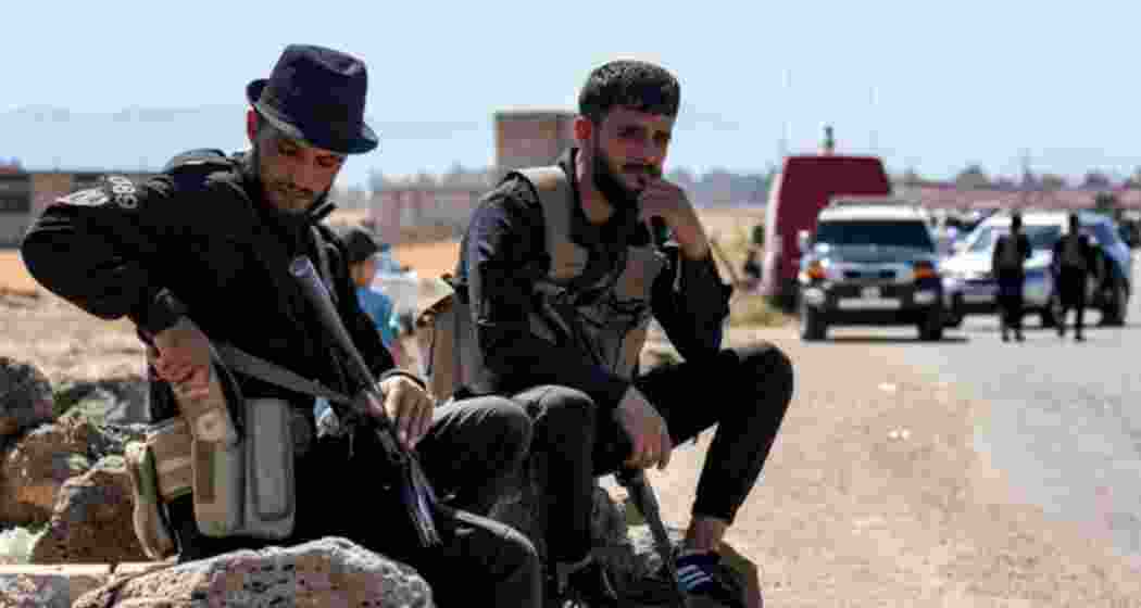Local faction members in Sweida, Syria, resting on a roadside after the government handed over security control following days of deadly sectarian clashes. Local faction members in Sweida, Syria, resting on a roadside after the government handed over security control following days of deadly sectarian clashes.